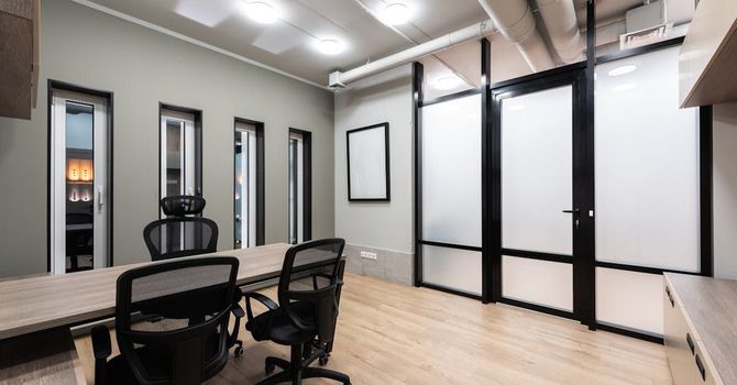 A small conference room with a long table and chairs.