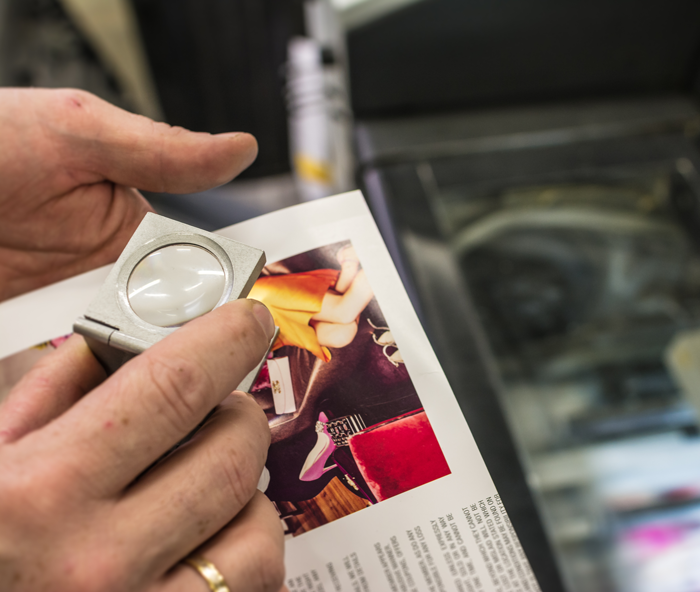 A person is holding a magnifying glass over a piece of paper