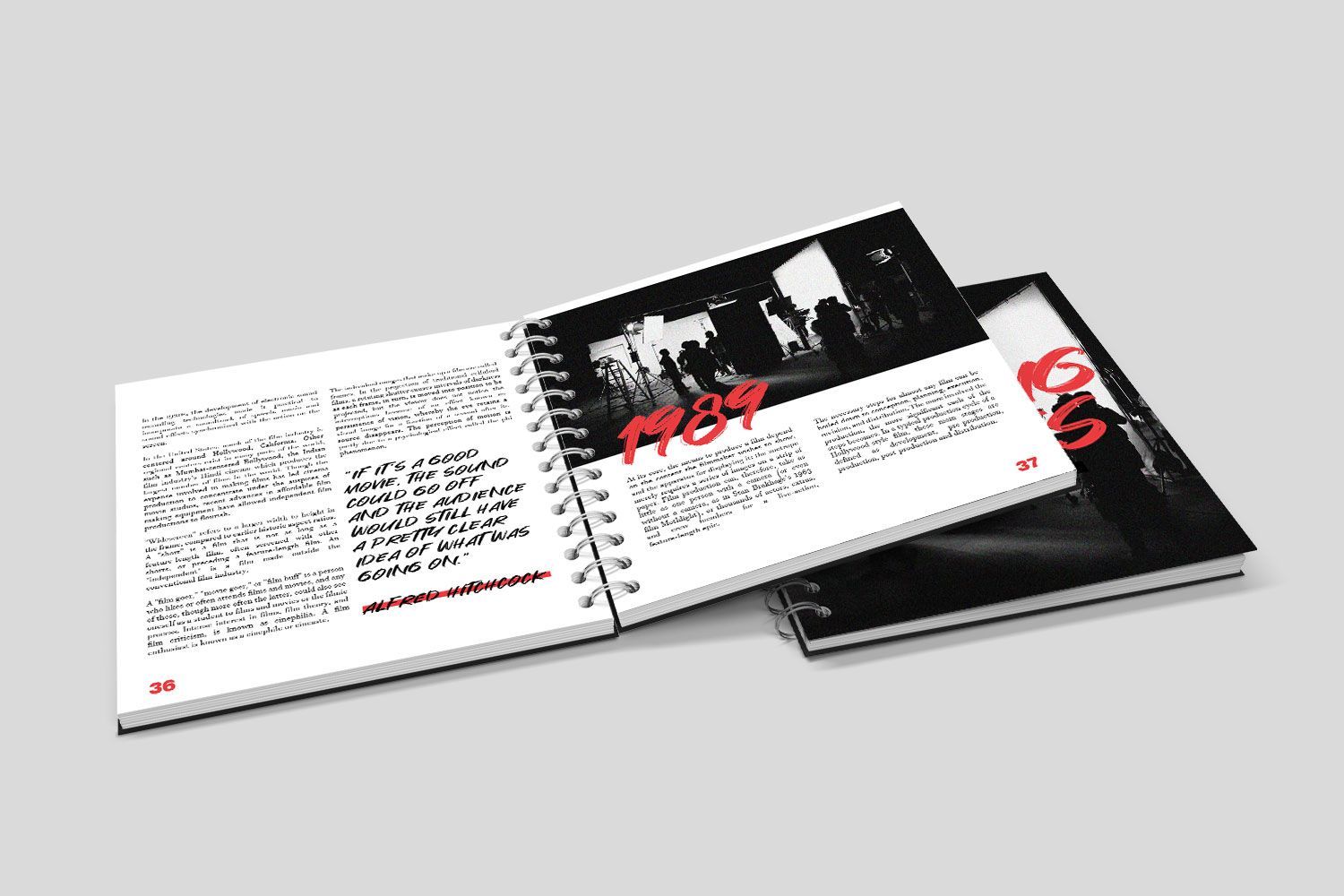 Two spiral bound books are stacked on top of each other on a white surface.