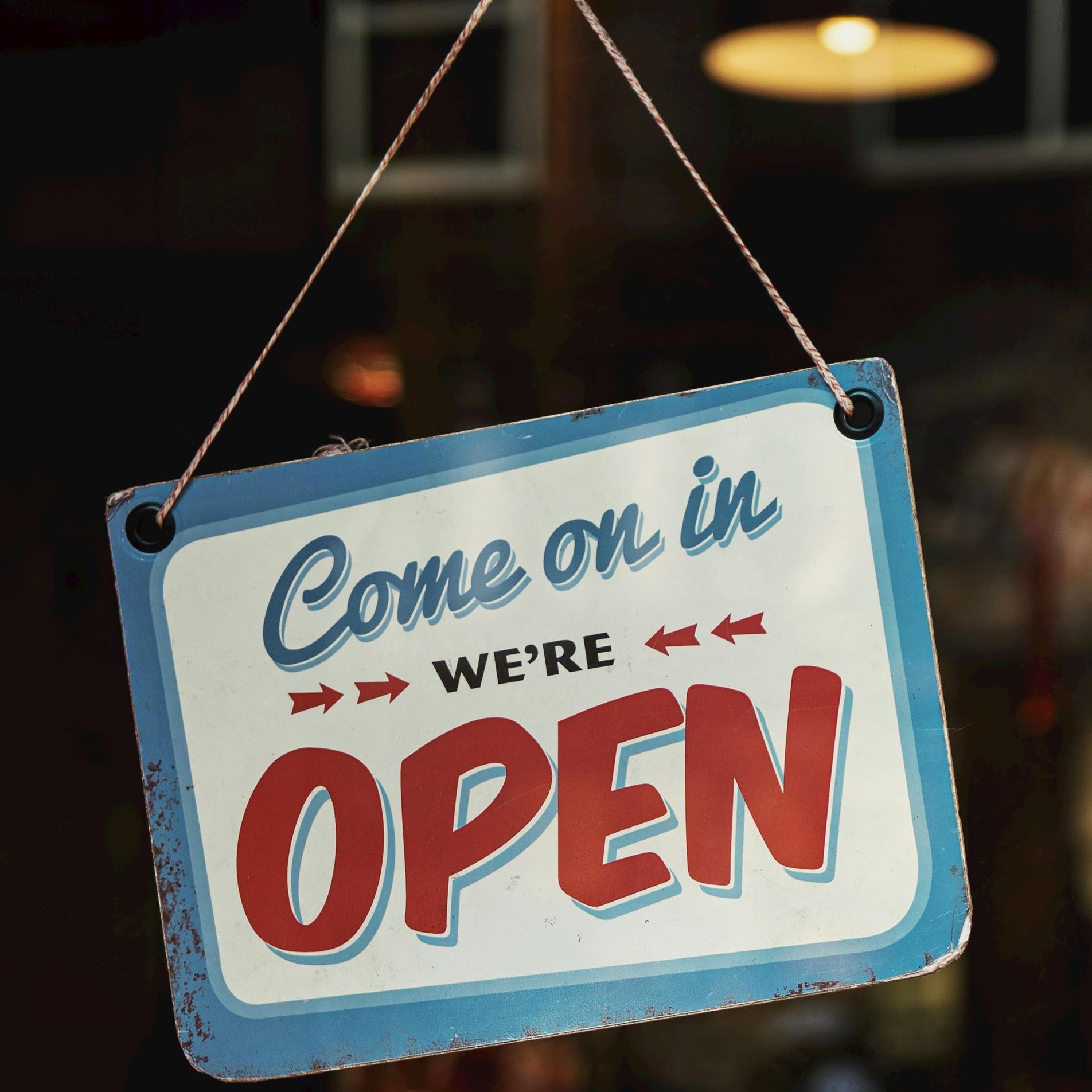 White sign with blue borde for a business with words in red saying