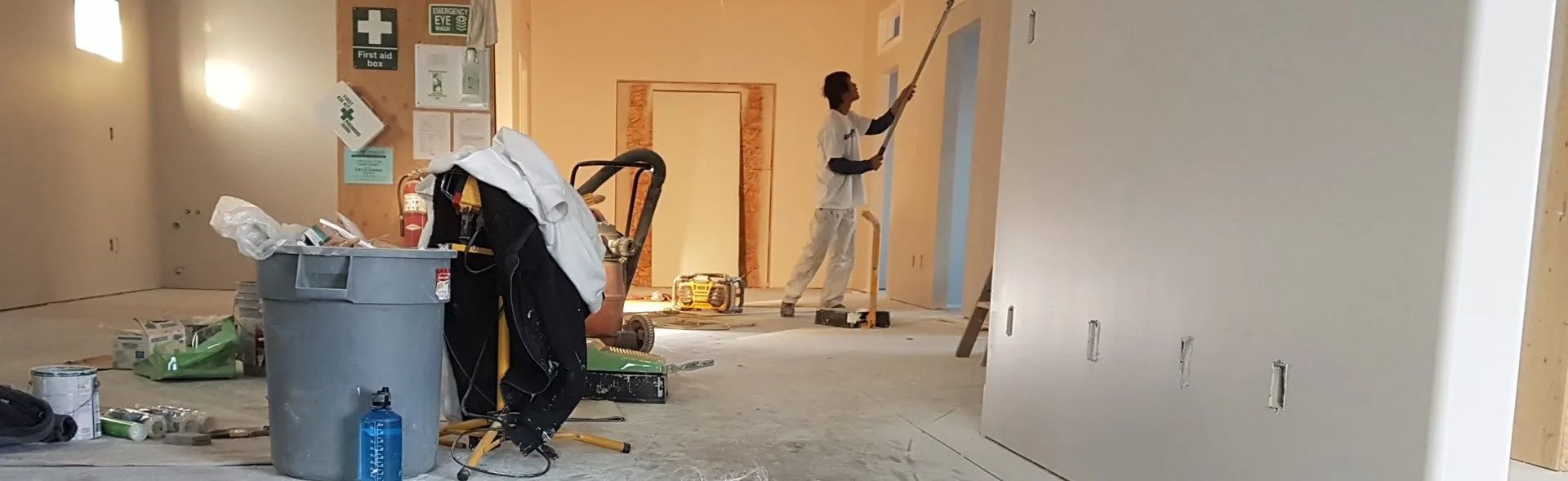 A man is painting a wall in a room.