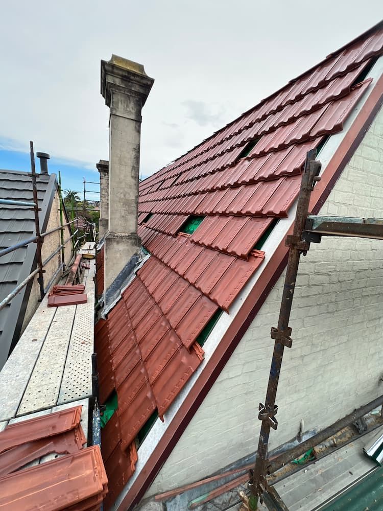 A Roof With Red Tiles and a Chimney on It — DC Roofing In Marsden Park, NSW