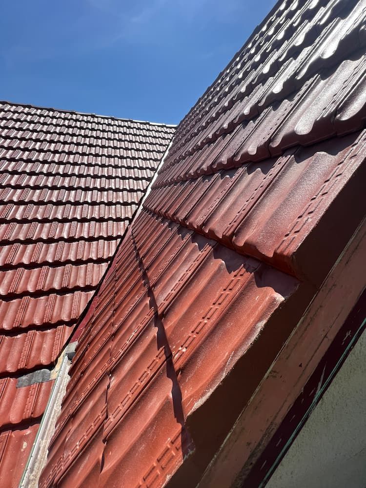 A Red Tiled Roof With a Blue Sky in the Background — DC Roofing In Marsden Park, NSW