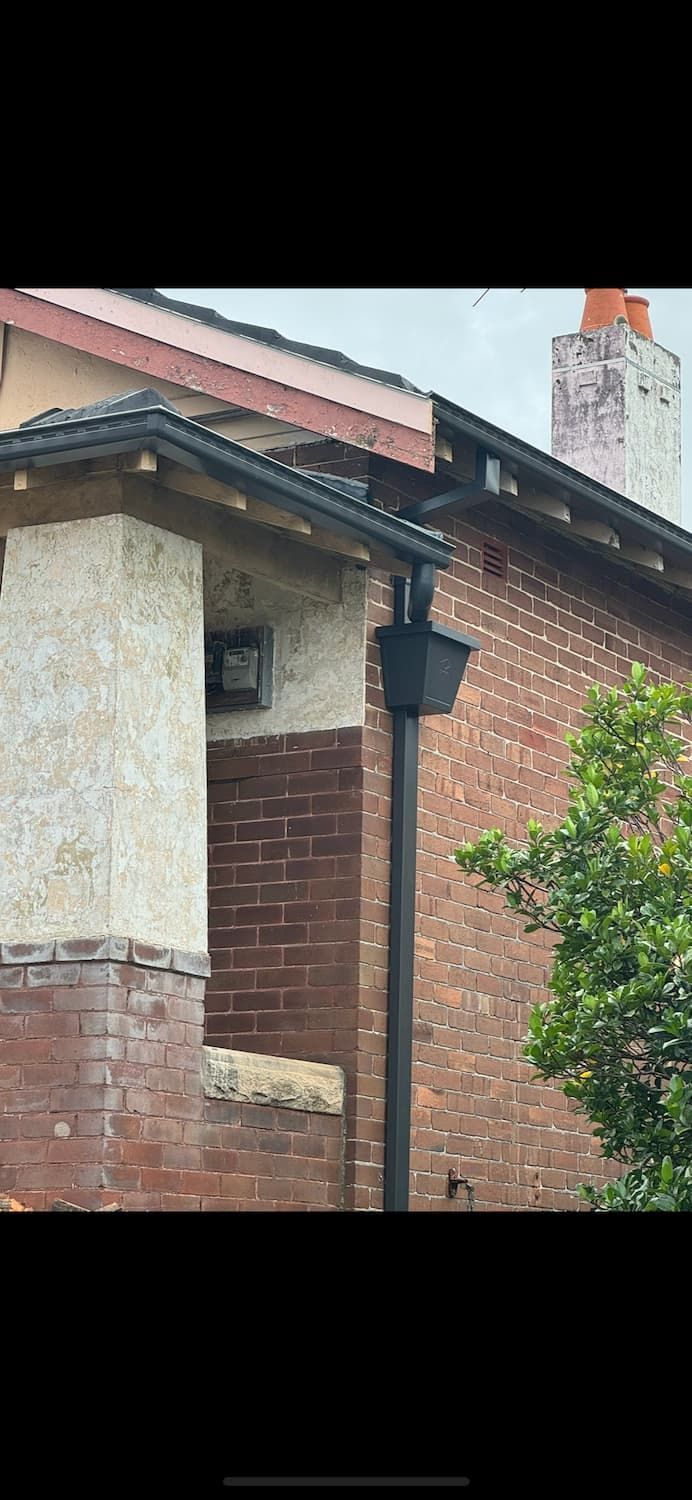 A Brick Building With a Gutter on the Side of It — DC Roofing In Eastwood, NSW