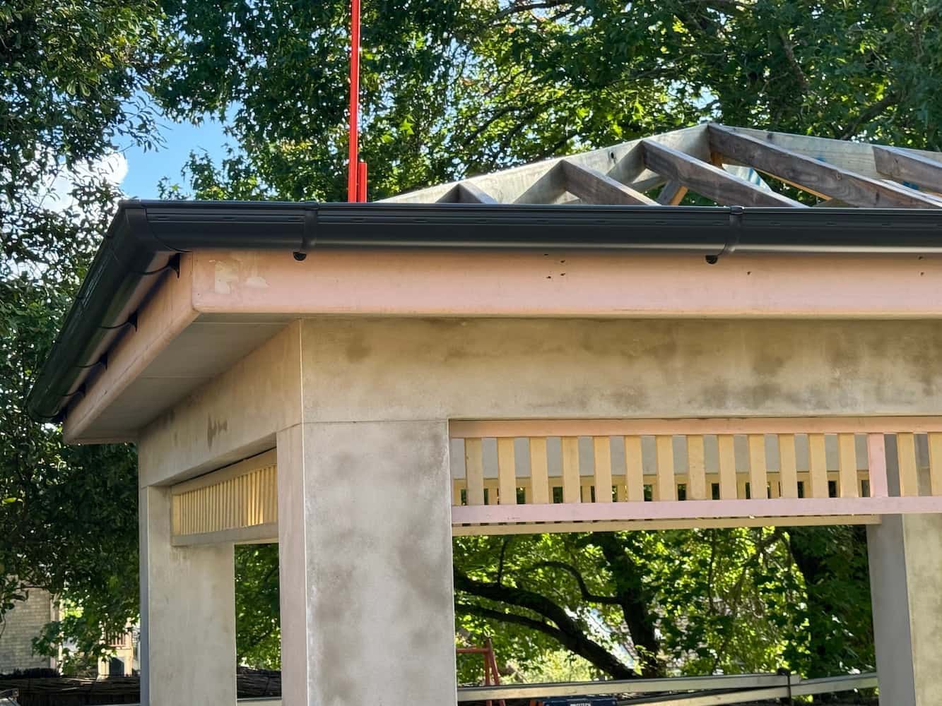 A Gazebo is Being Built With a Crane Hanging From the Roof — DC Roofing In Marsden Park, NSW