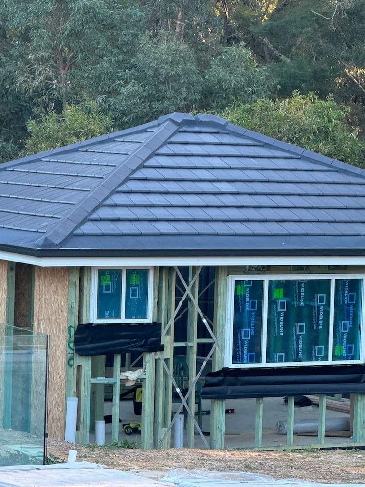 A House That is Being Built With a Blue Roof — DC Roofing In Baulkham Hills, NSW
