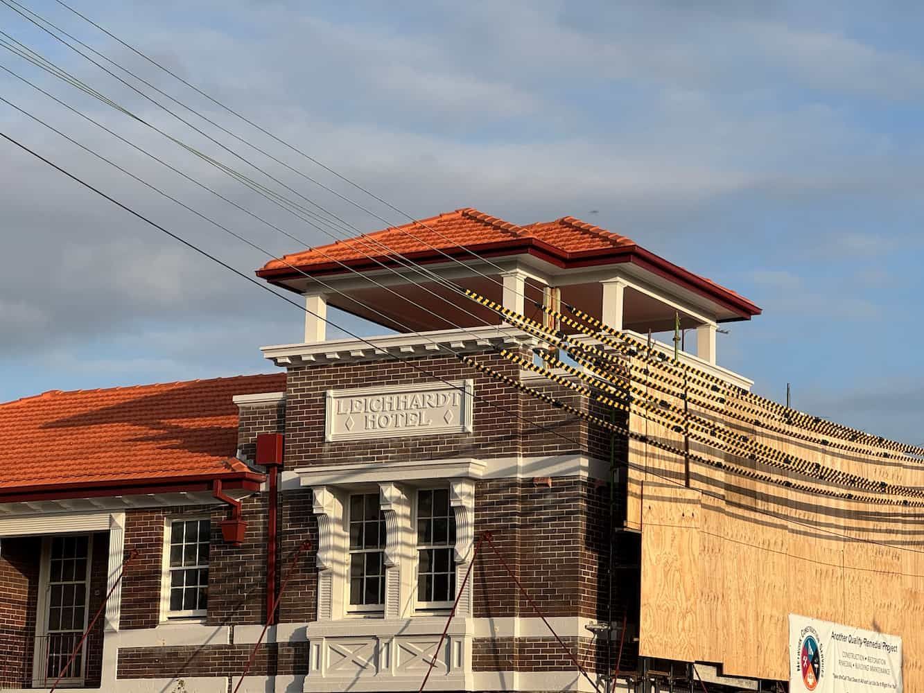 A Large Brick Building With a Red Tile Roof — DC Roofing n Baulkham Hills, NSW