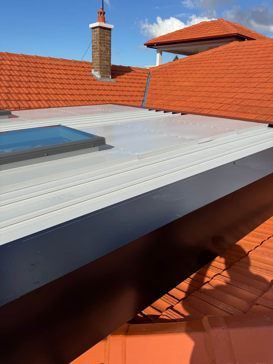A Roof With a Skylight and a Chimney on It — DC Roofing In Marsden Park, NSW
