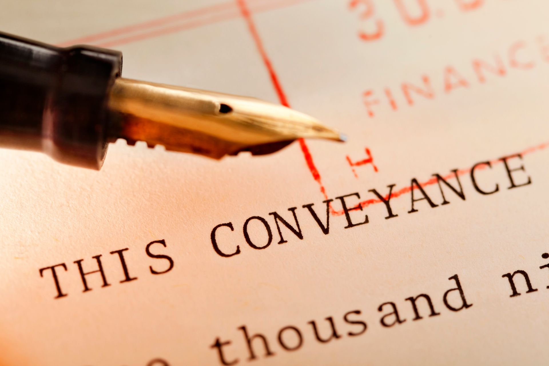 Conveyancing legal documents with antique pen symbolizing property transfer.