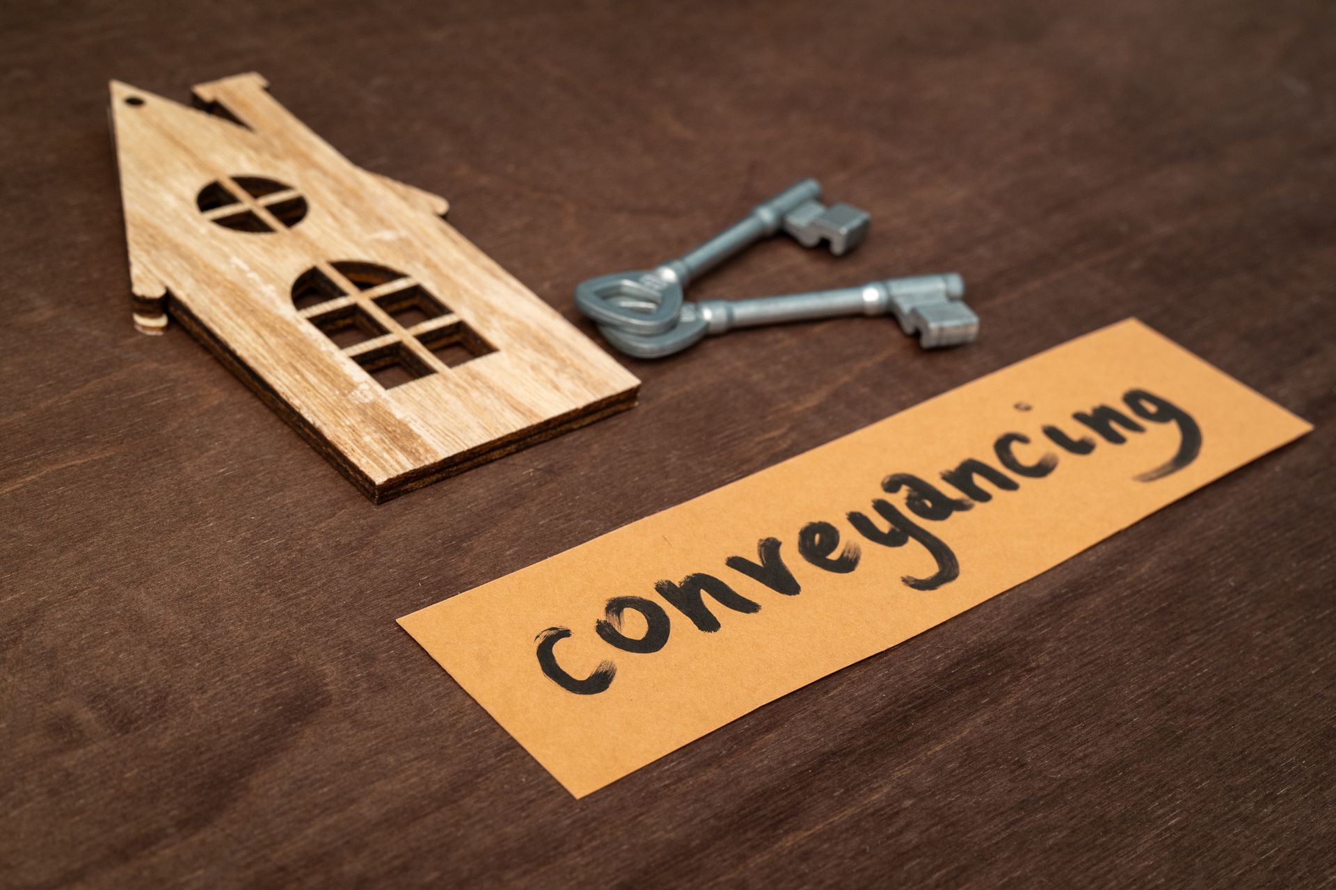 Cut-out wooden house representation of the conveyancing process. Cut-out wooden house representation of the conveyancing process.