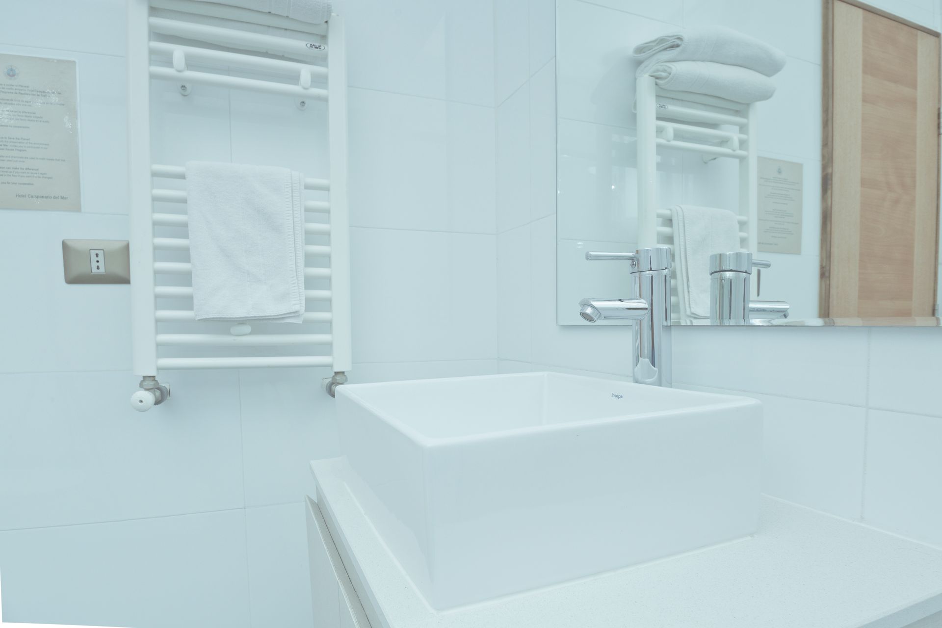 A bathroom with a sink , mirror and towel rack.