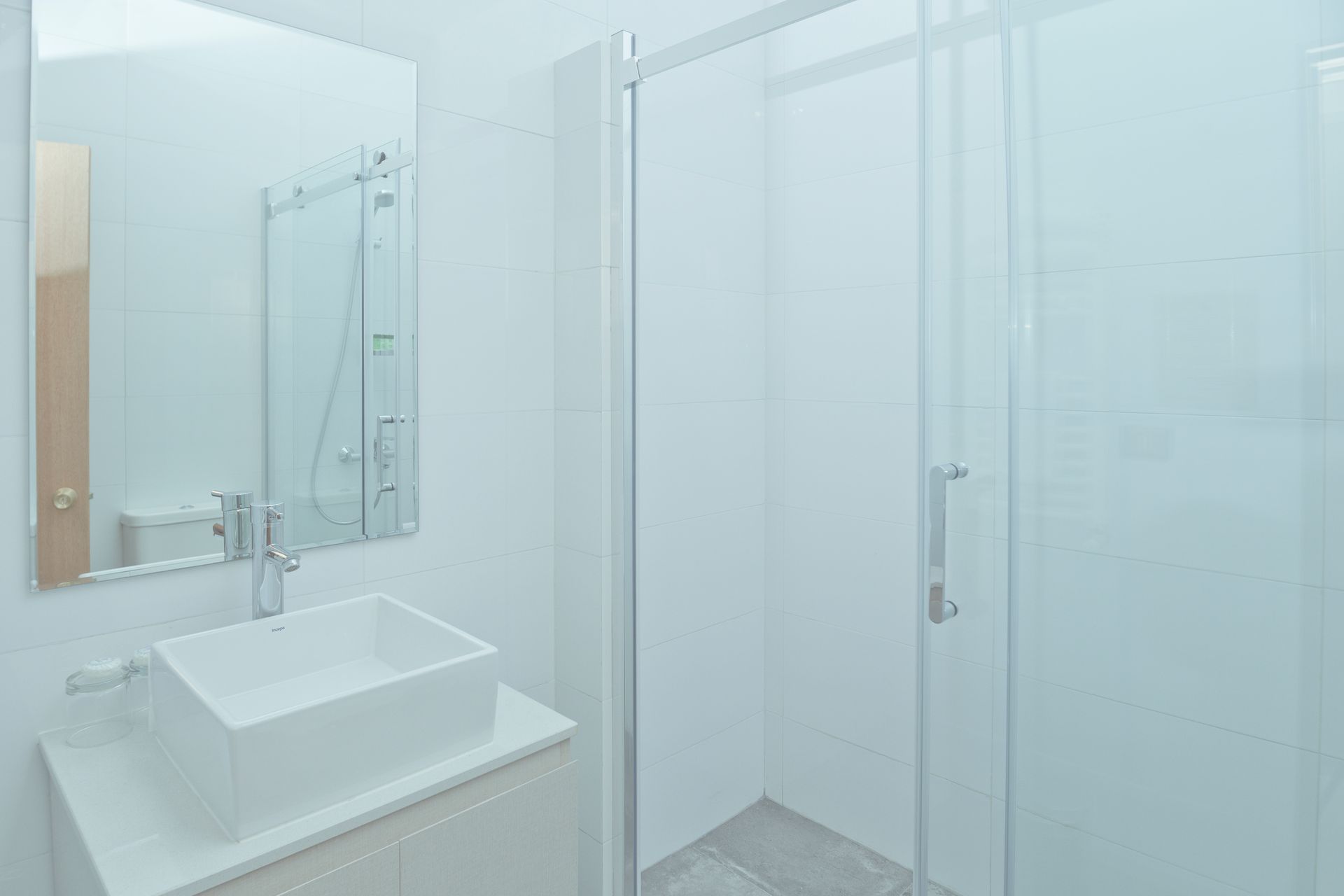 A bathroom with a sink , mirror and shower stall.