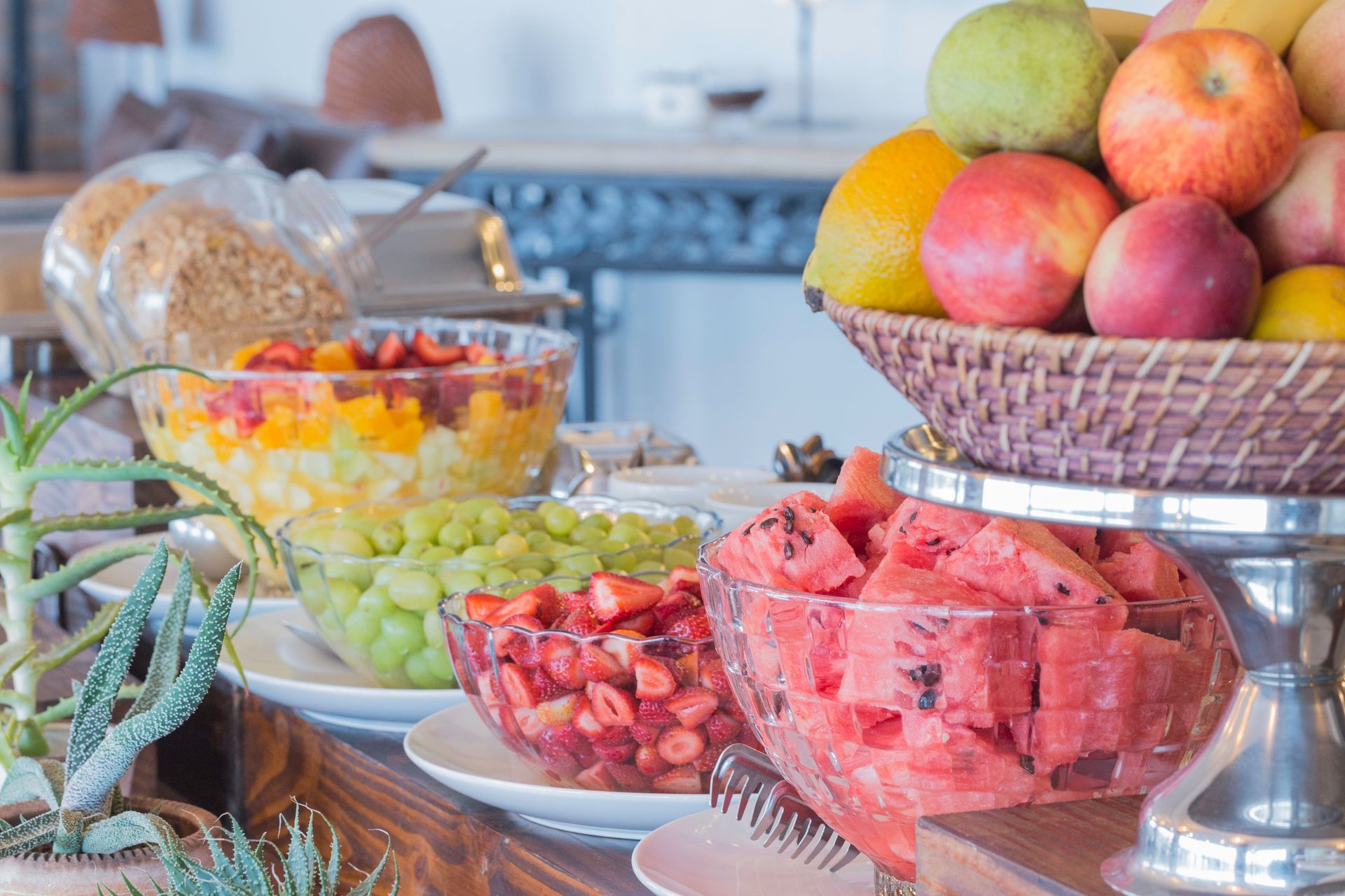 A table topped with bowls of fruit and a basket of fruit.