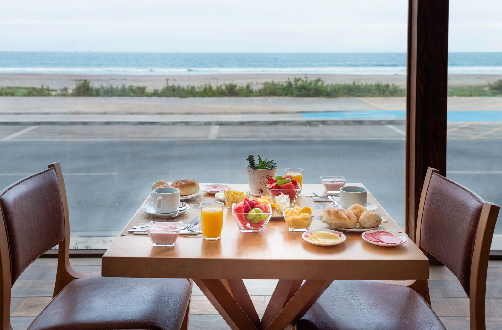 A table with food on it and a view of the ocean.