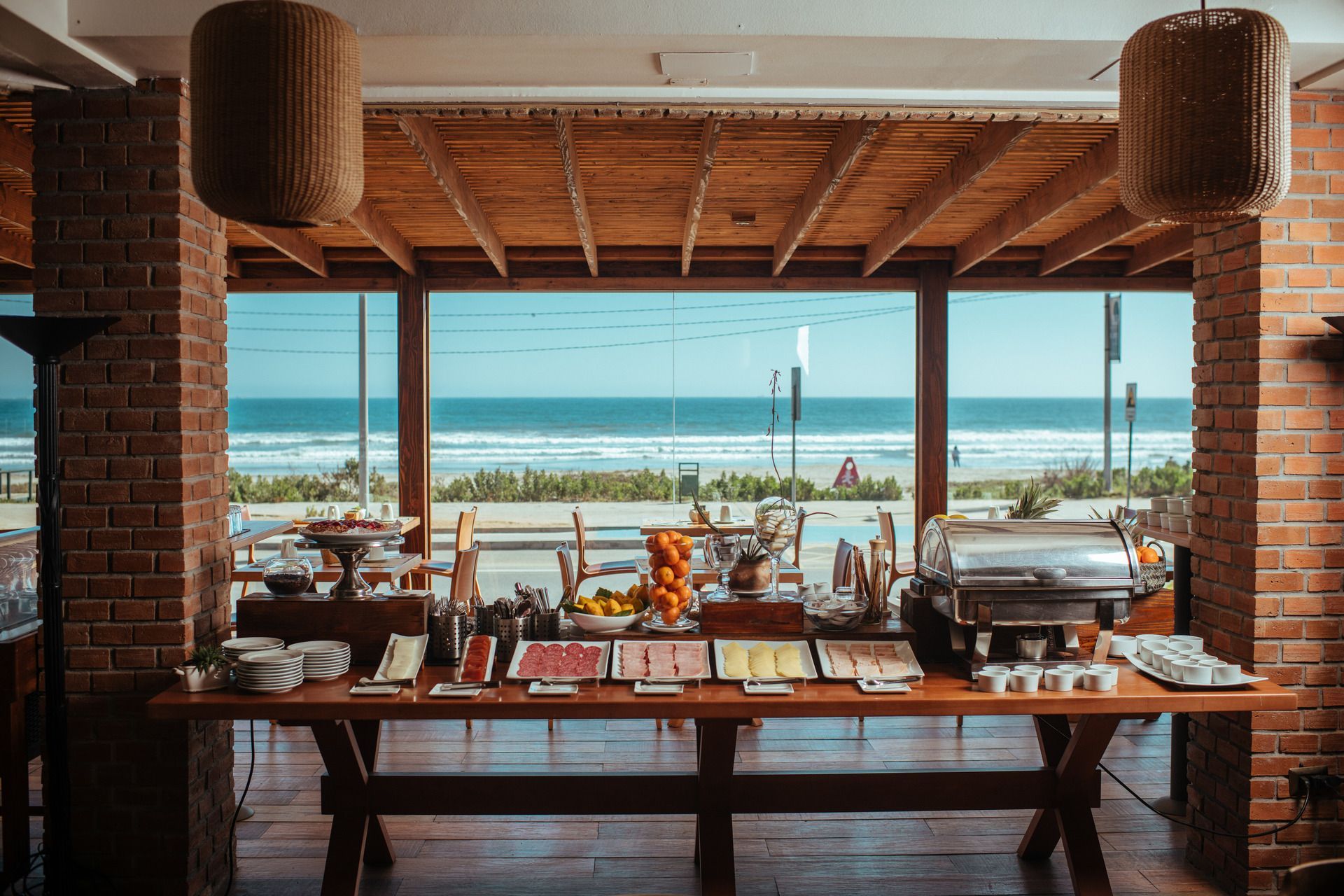There is a table with a lot of food on it and a view of the ocean.