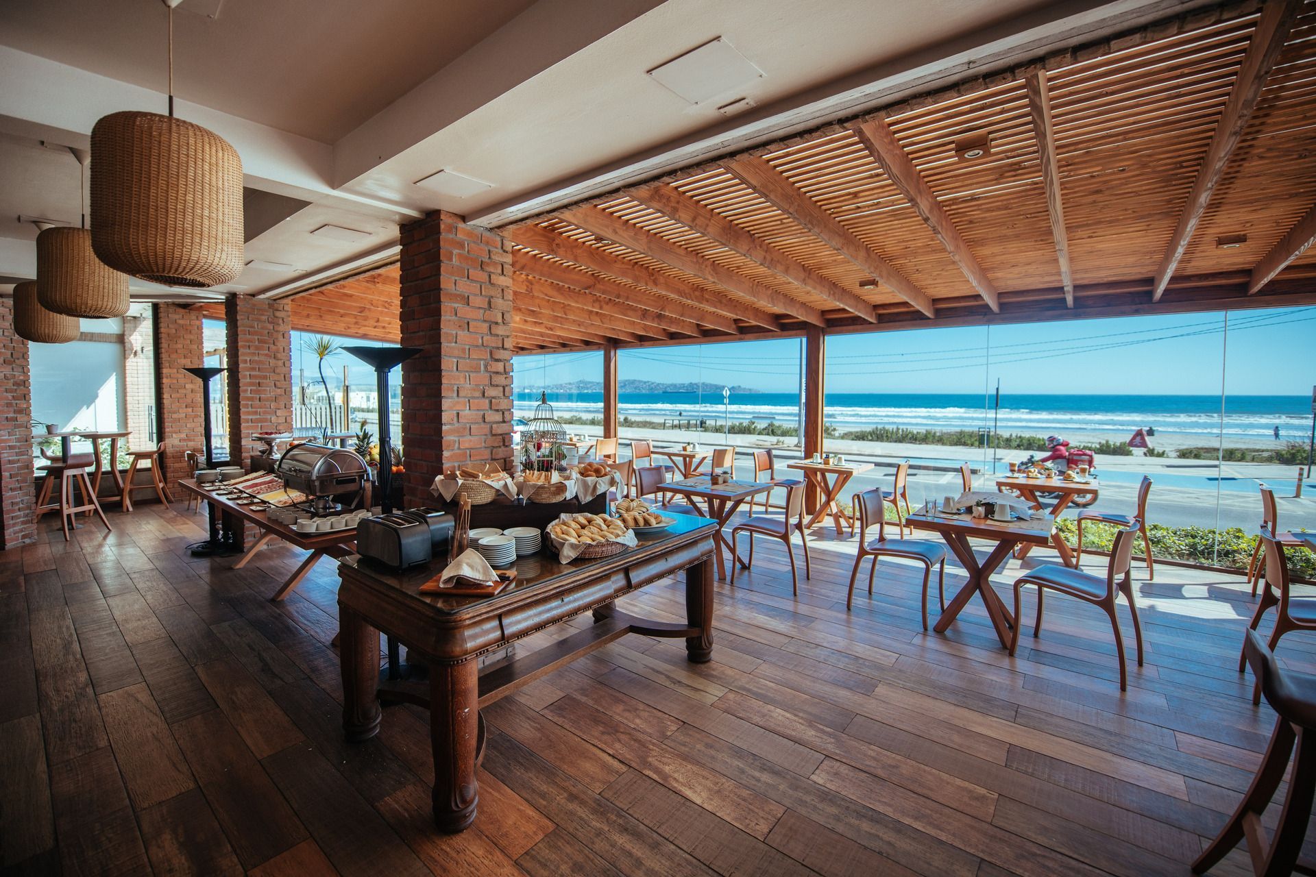 A restaurant with tables and chairs and a view of the ocean.