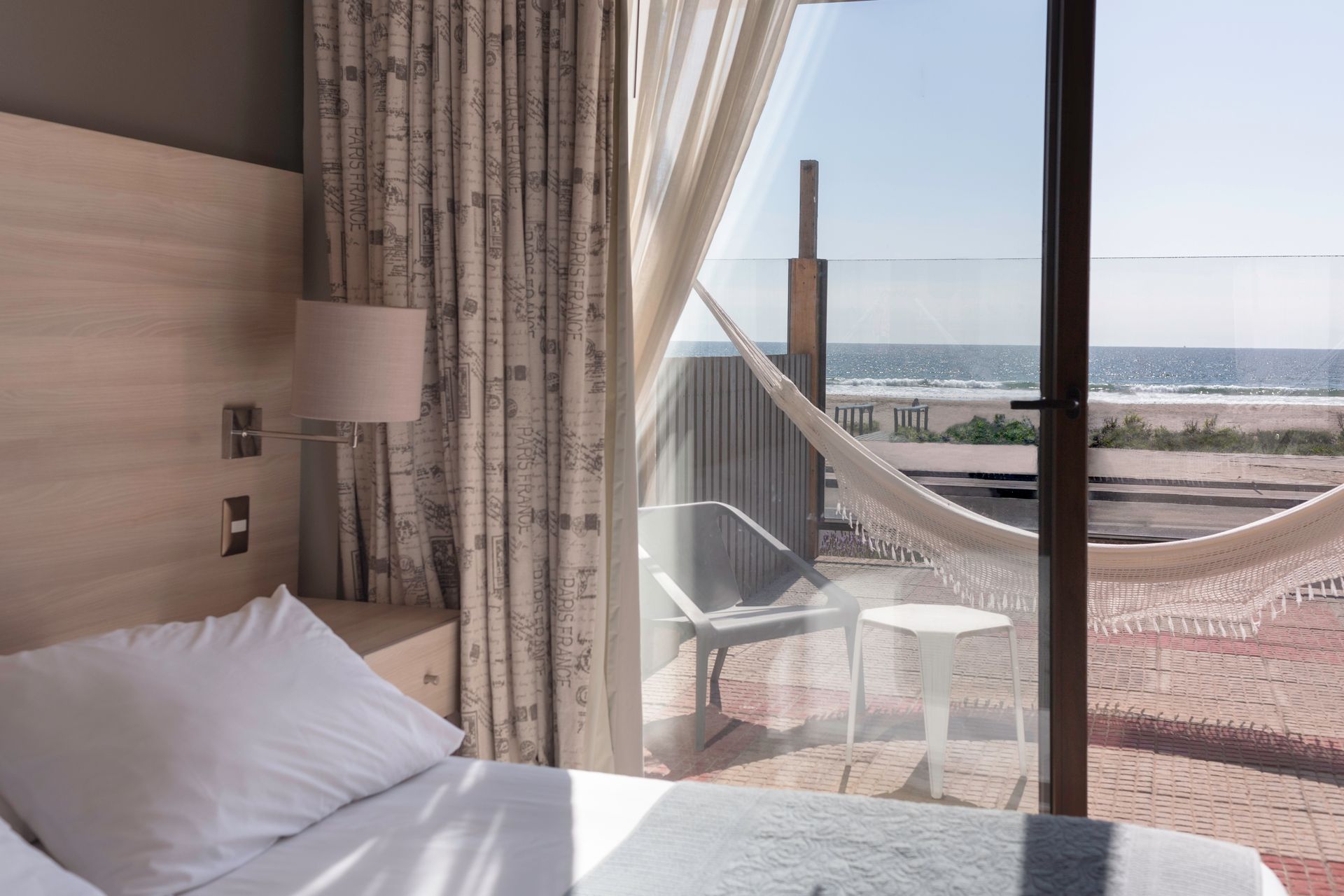 A hotel room with a hammock and a view of the ocean.