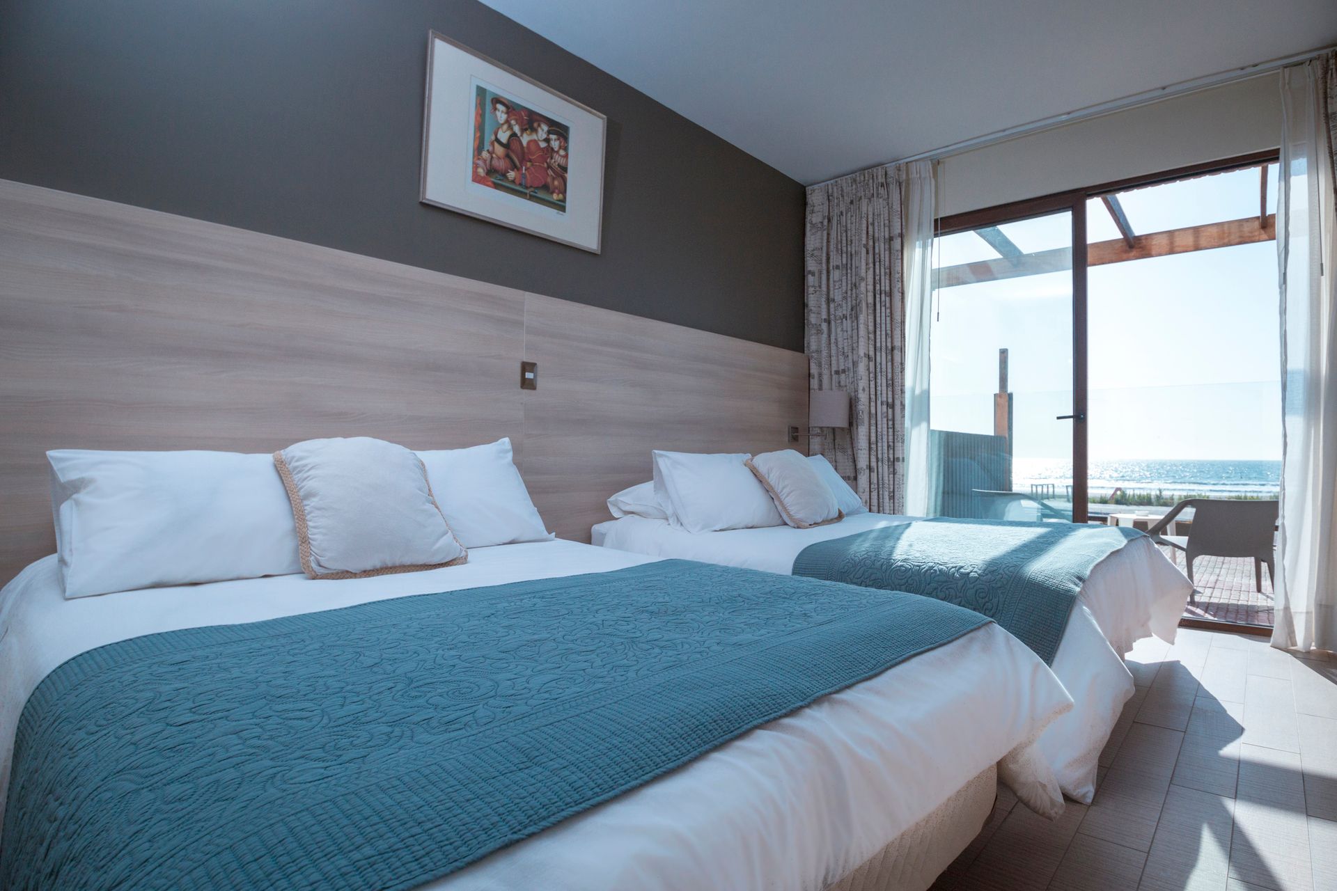 A hotel room with two beds and a large window.