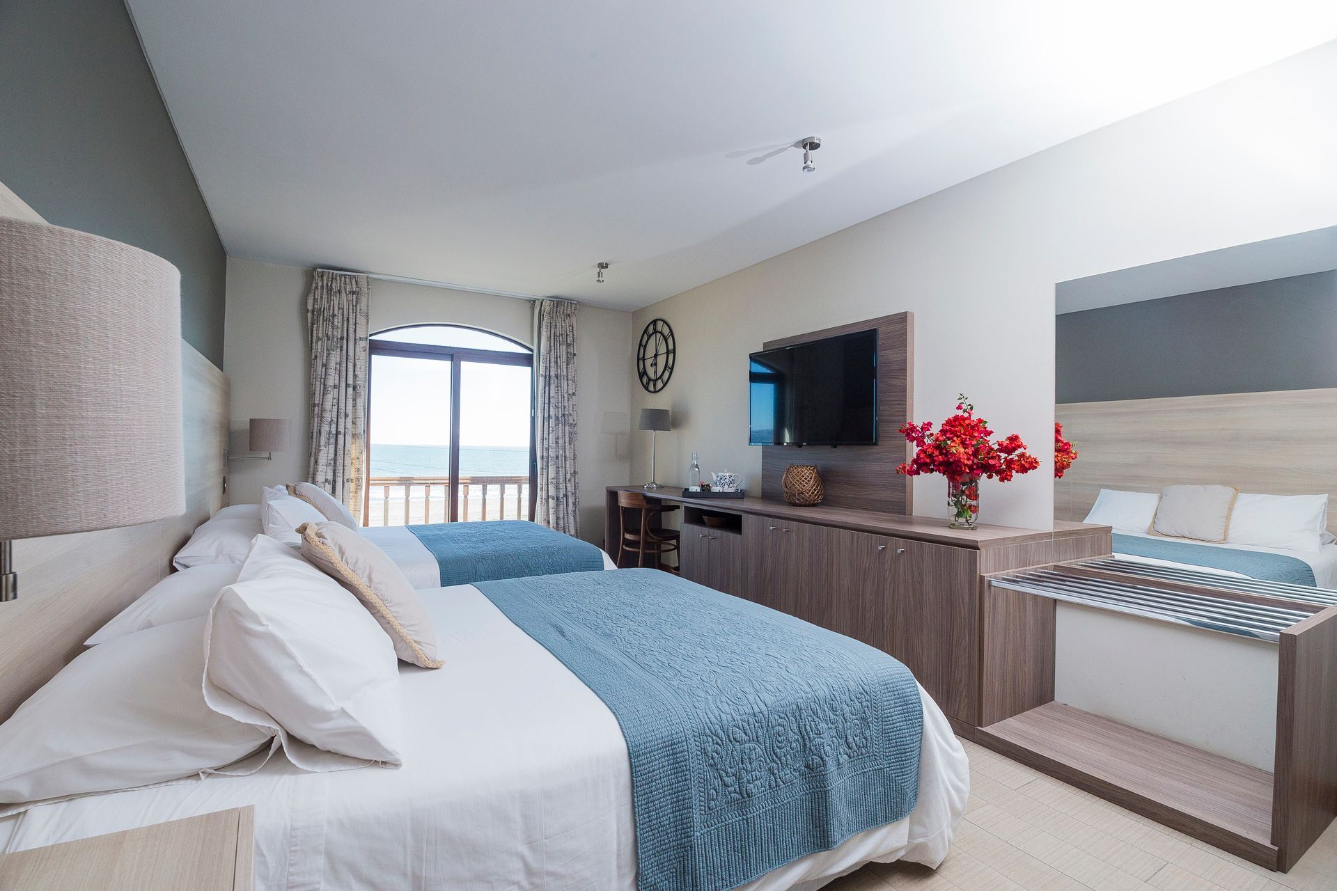A hotel room with two beds and a flat screen tv.