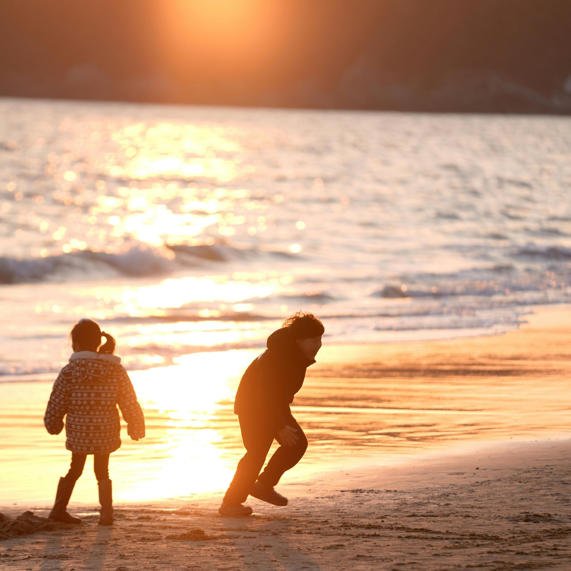 Niños jugando al atardecer en la playa de La Serena durante unas vacaciones familiares.