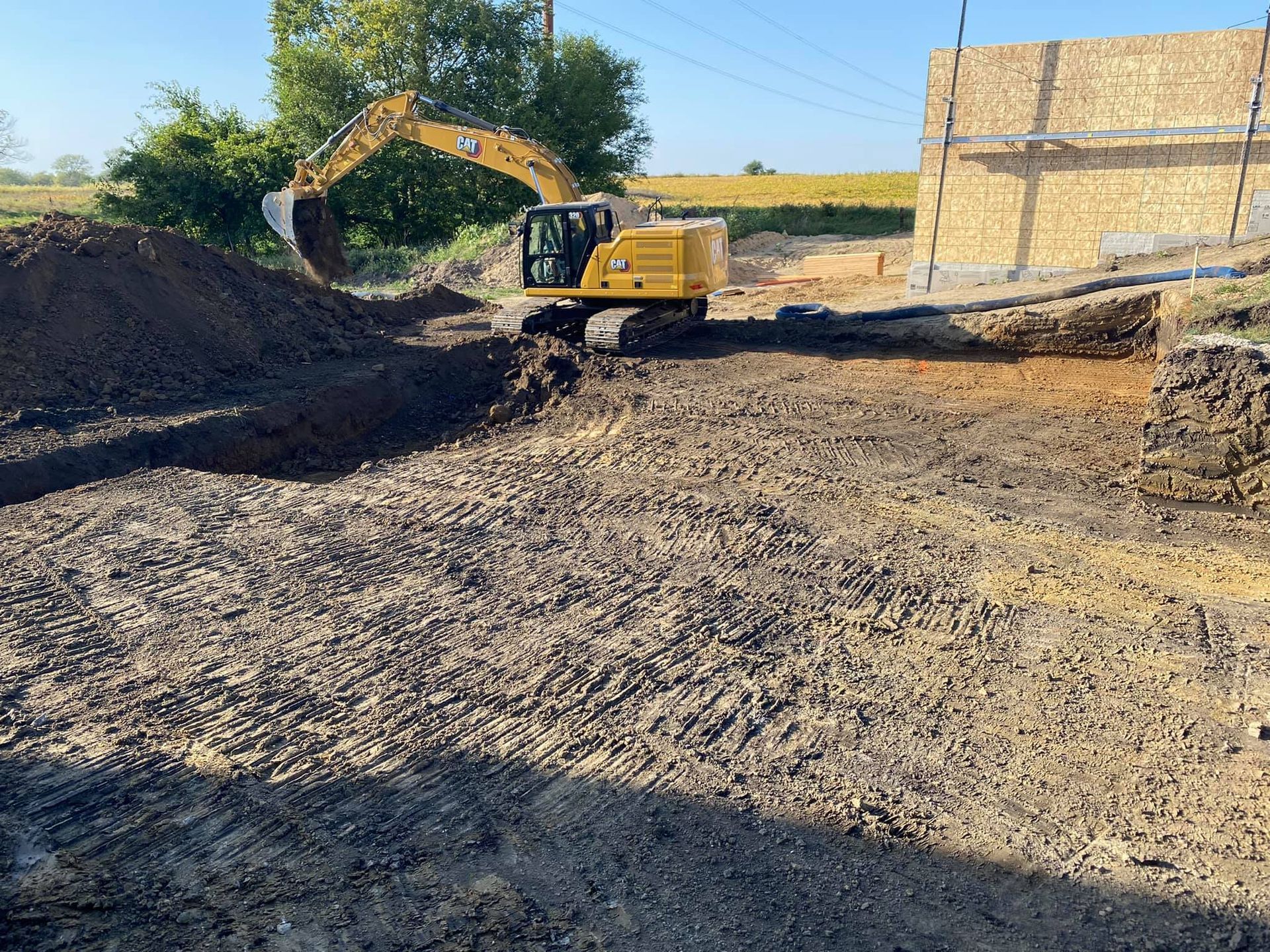 A yellow excavator is digging a hole in the dirt.