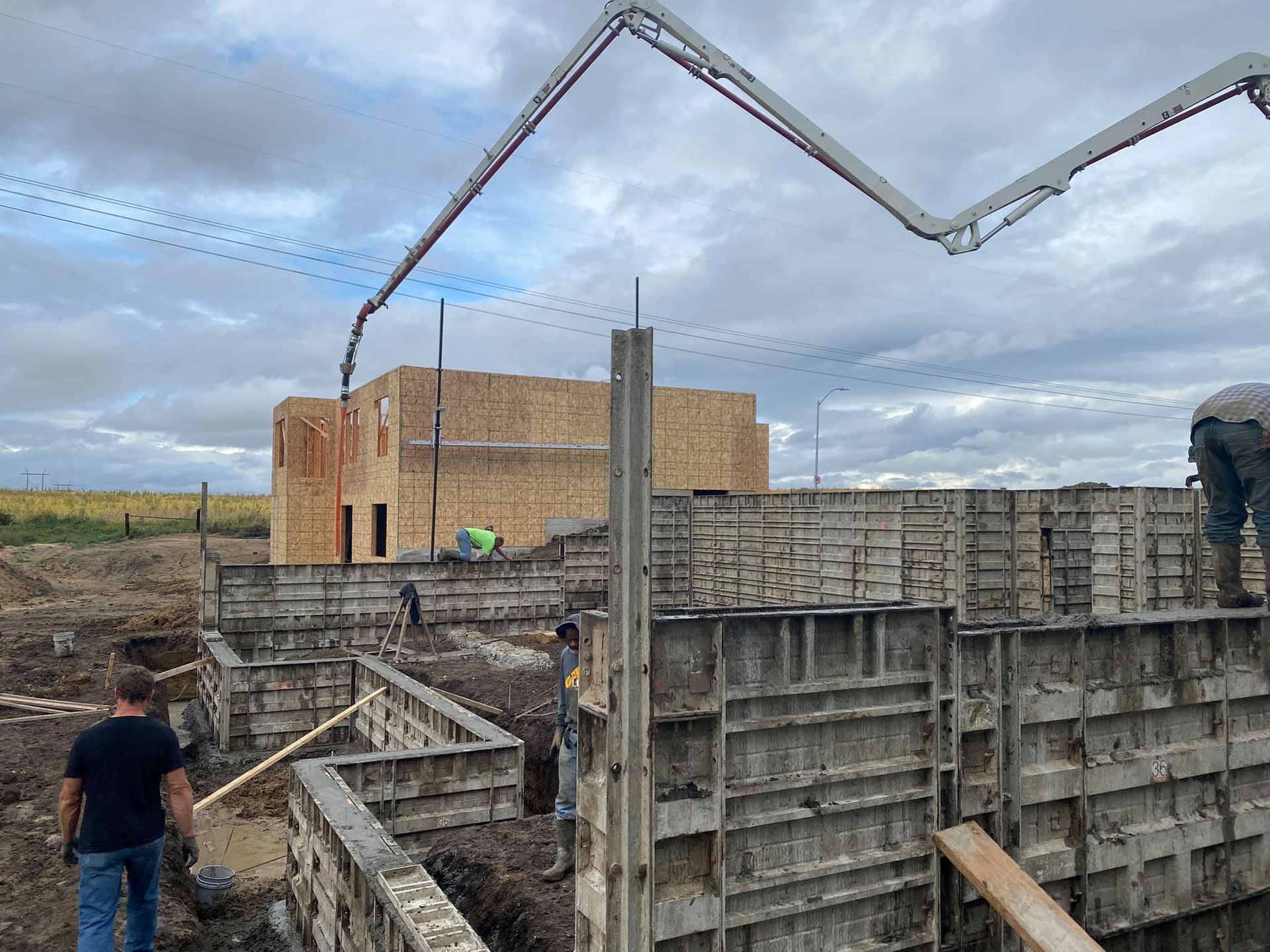 A group of construction workers are working on the foundation of a house.