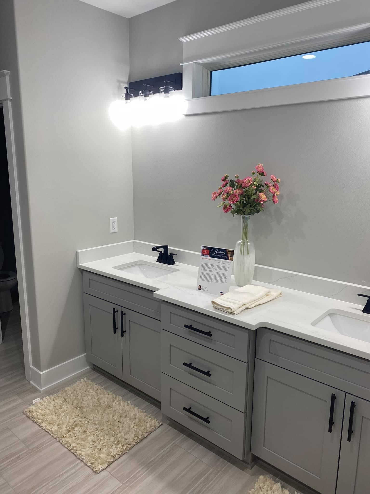 A bathroom with two sinks and a window.