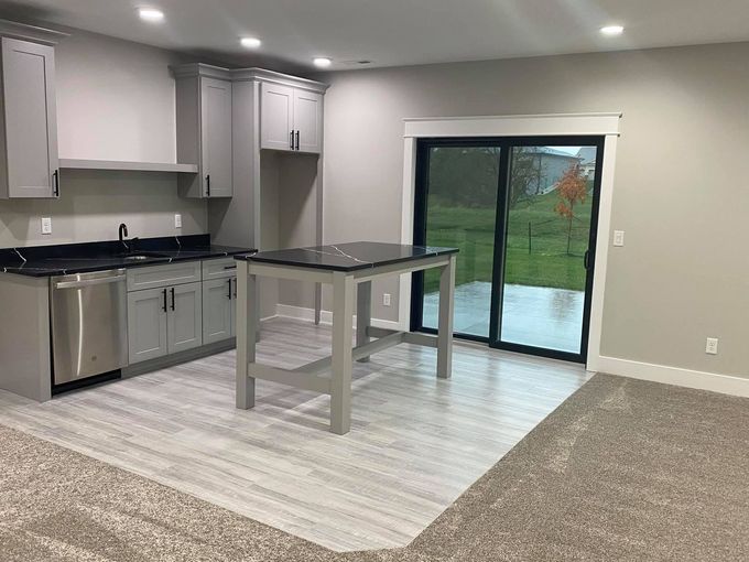 A kitchen with a table and a sliding glass door.