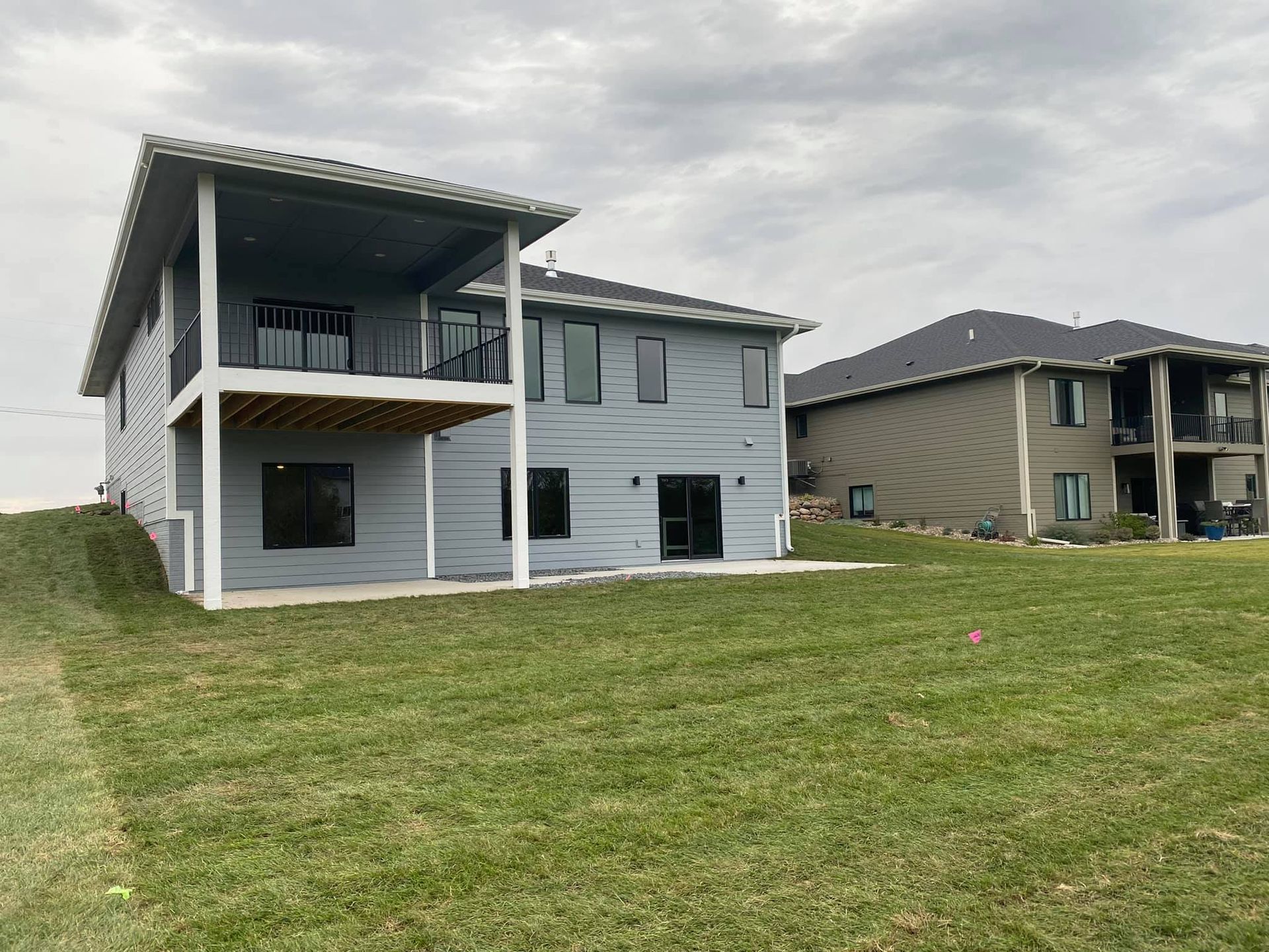A large house is sitting in the middle of a lush green field.