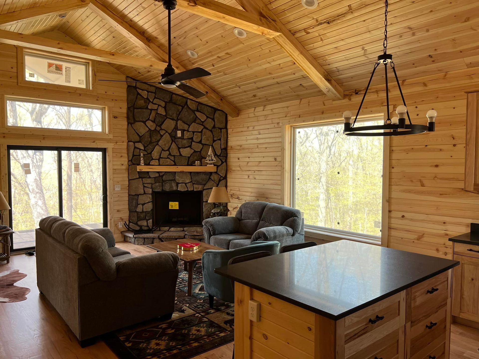 A living room in a log cabin with a fireplace and a couch.