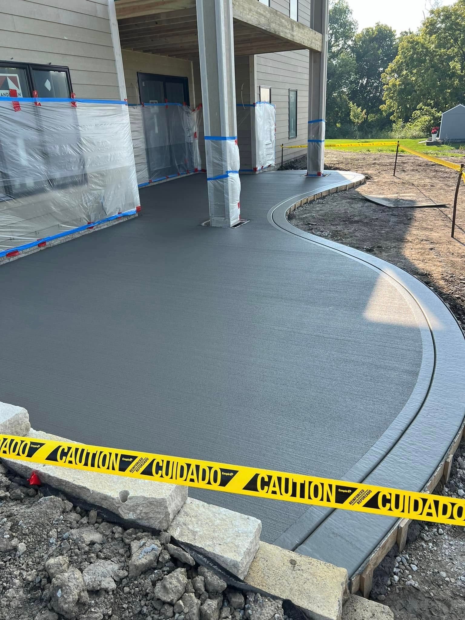 A concrete walkway is being built in front of a house.