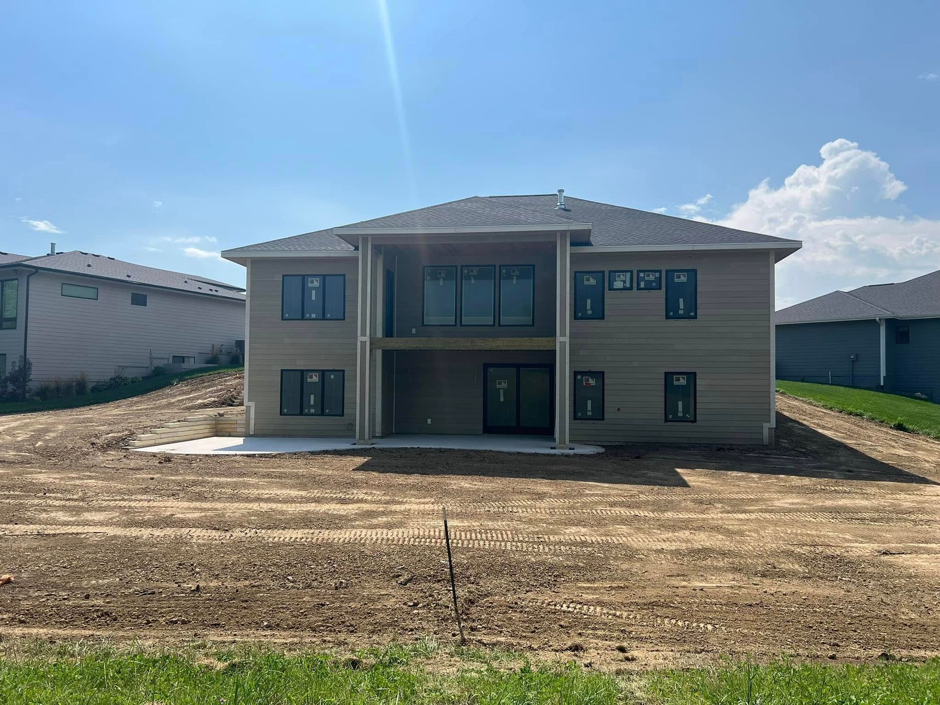 A large house is sitting on top of a dirt field.