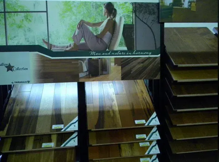 Display of hardwood flooring samples with advertisement showing a person in a serene setting.