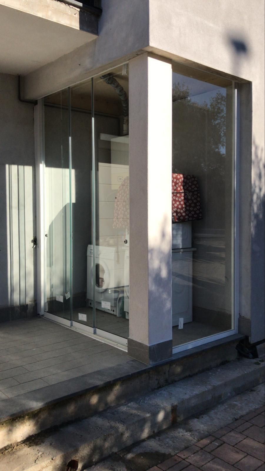 Stanza chiusa da vetrate con una colonna bianca, in cui sono alloggiati gli elettrodomestici.