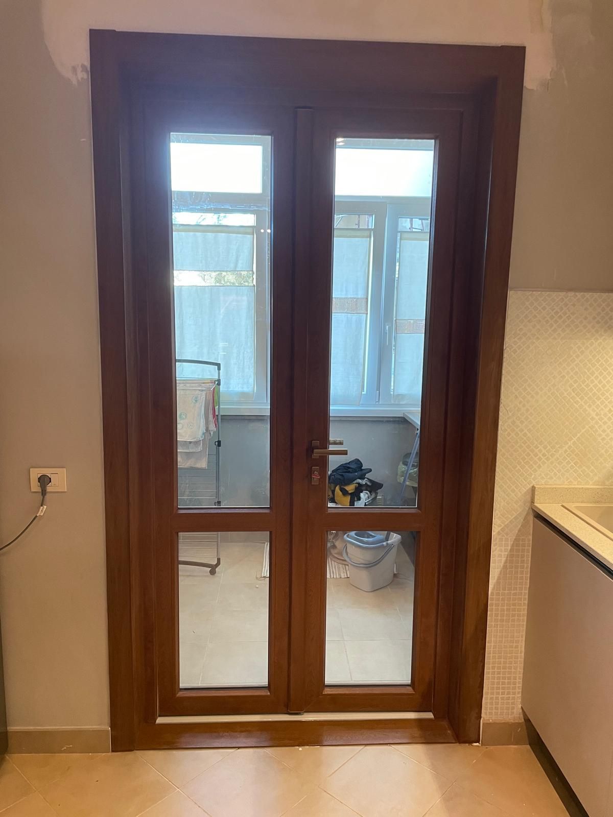 Doppie porte in legno con vetri che conducono a un balcone. 