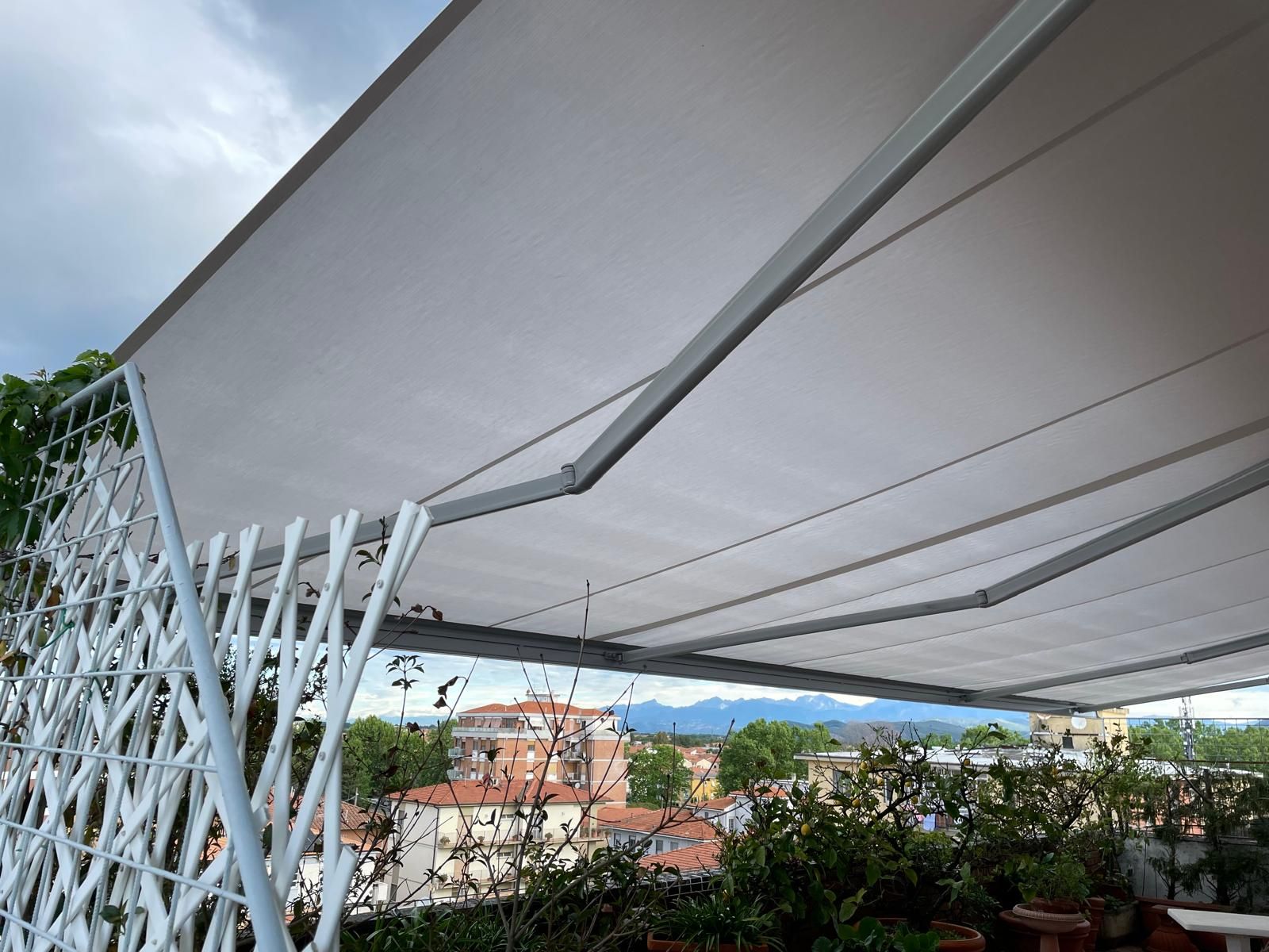 Tenda da sole bianca retrattile sopra un patio sul tetto. 