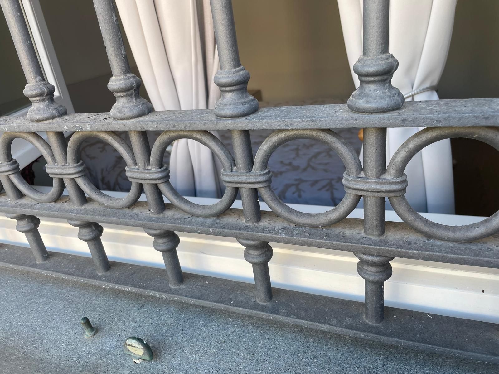 Primo piano di una griglia decorativa in metallo grigio per finestre con barre circolari e verticali