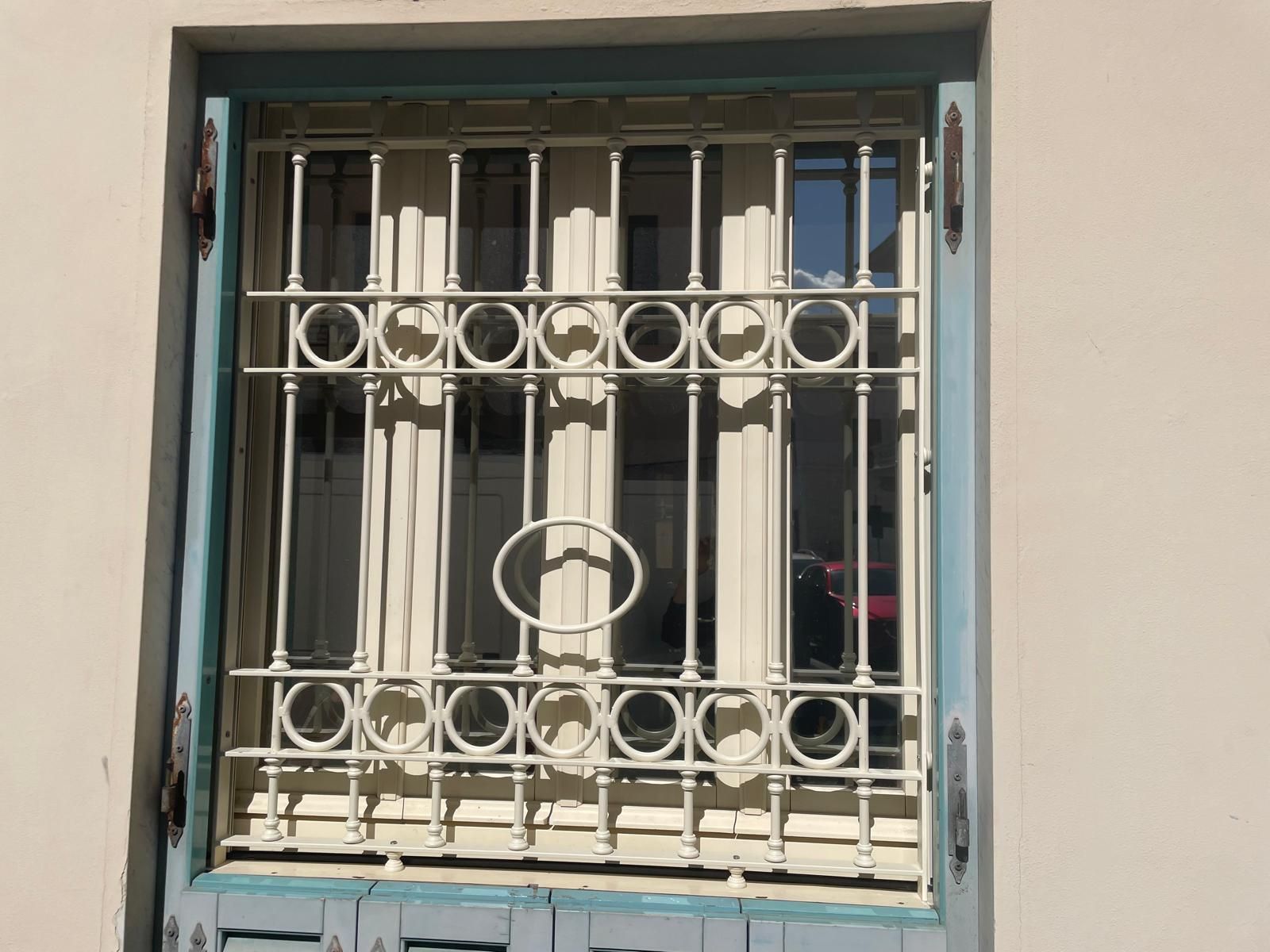 Finestra con sbarre bianche e cornice blu.