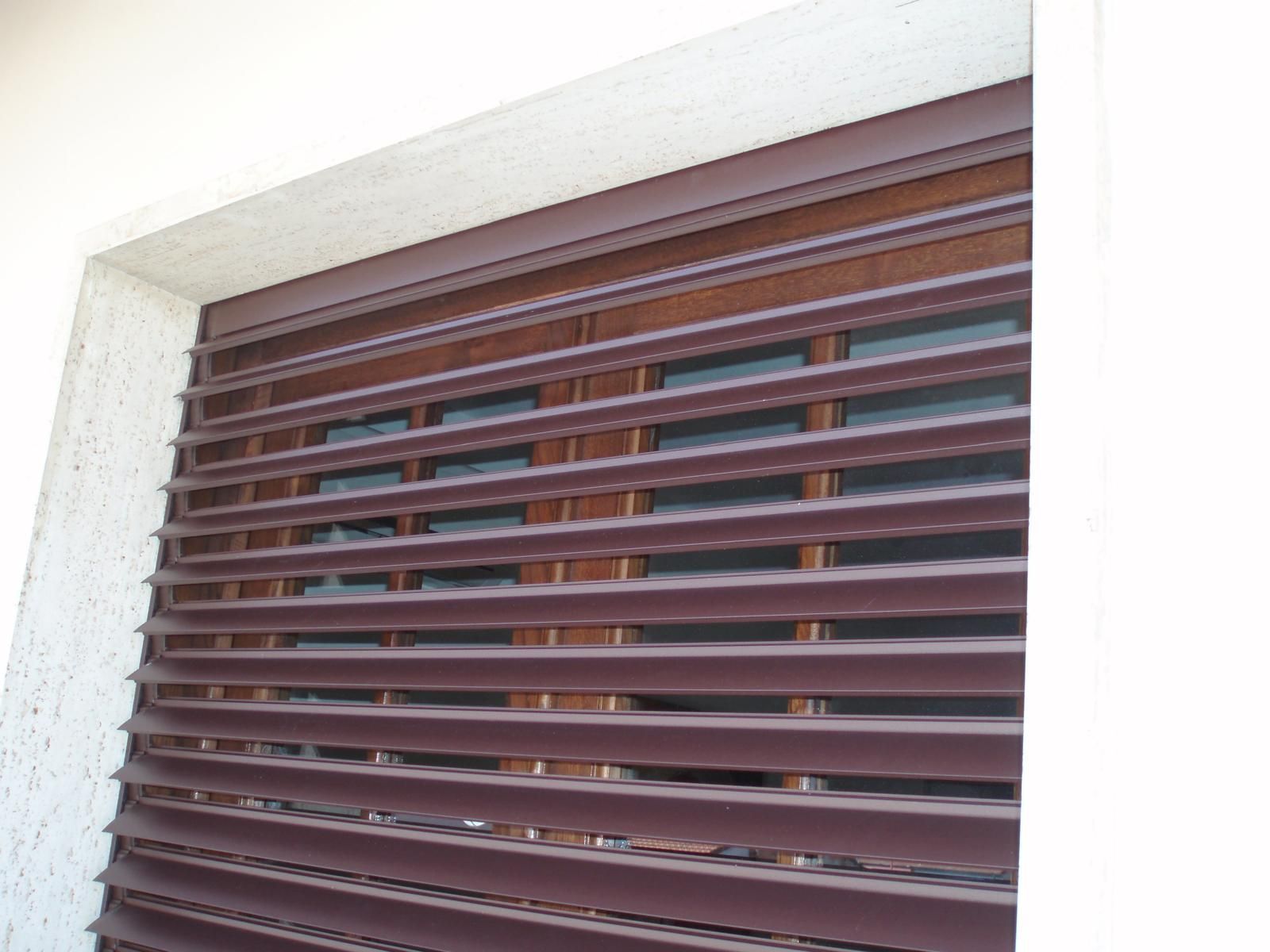 Persiane avvolgibili orizzontali marroni che coprono una finestra.