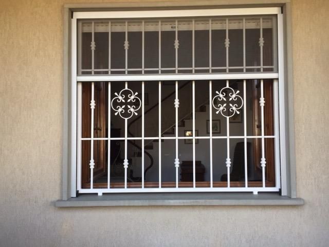Finestra bianca con inferriate di sicurezza.