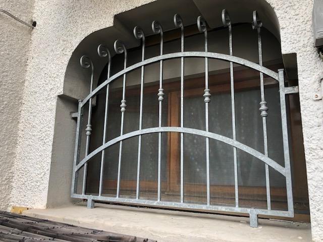 Inferriate di sicurezza metalliche sulla finestra ad arco.