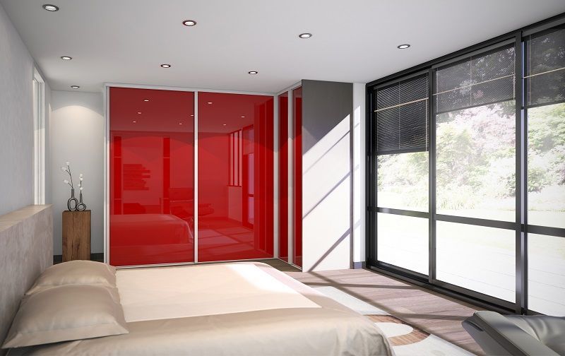 Camera da letto con ante scorrevoli rosse, ampia finestra e letto.