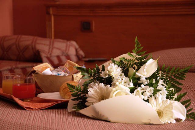 un mazzo di fiori appoggiato su un letto di un resort