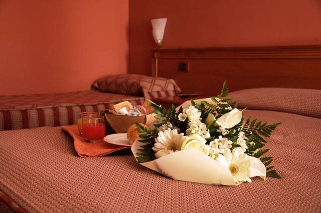 un letto matrimoniale con un mazzo di fiori