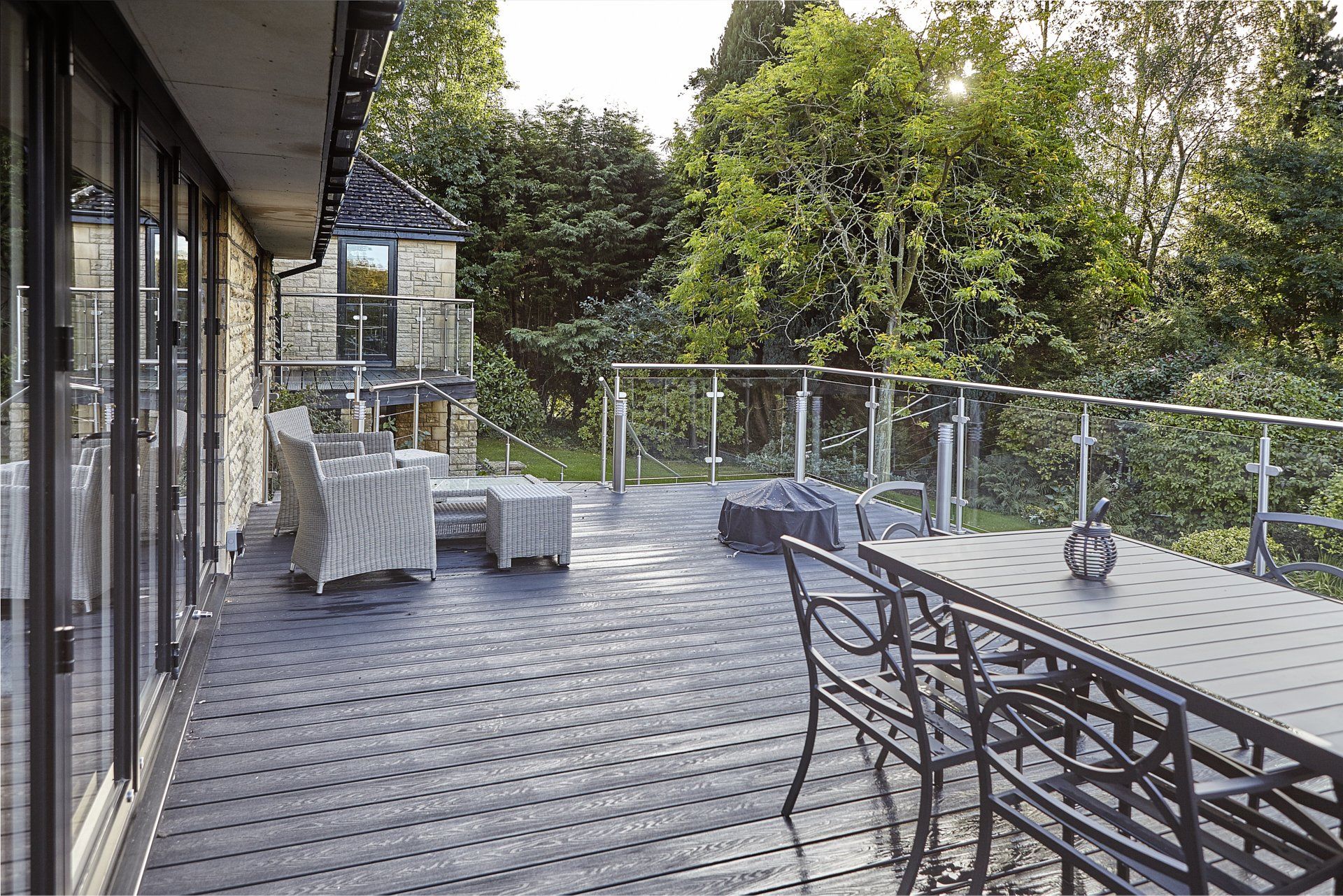 There is a large deck with a table and chairs on it.