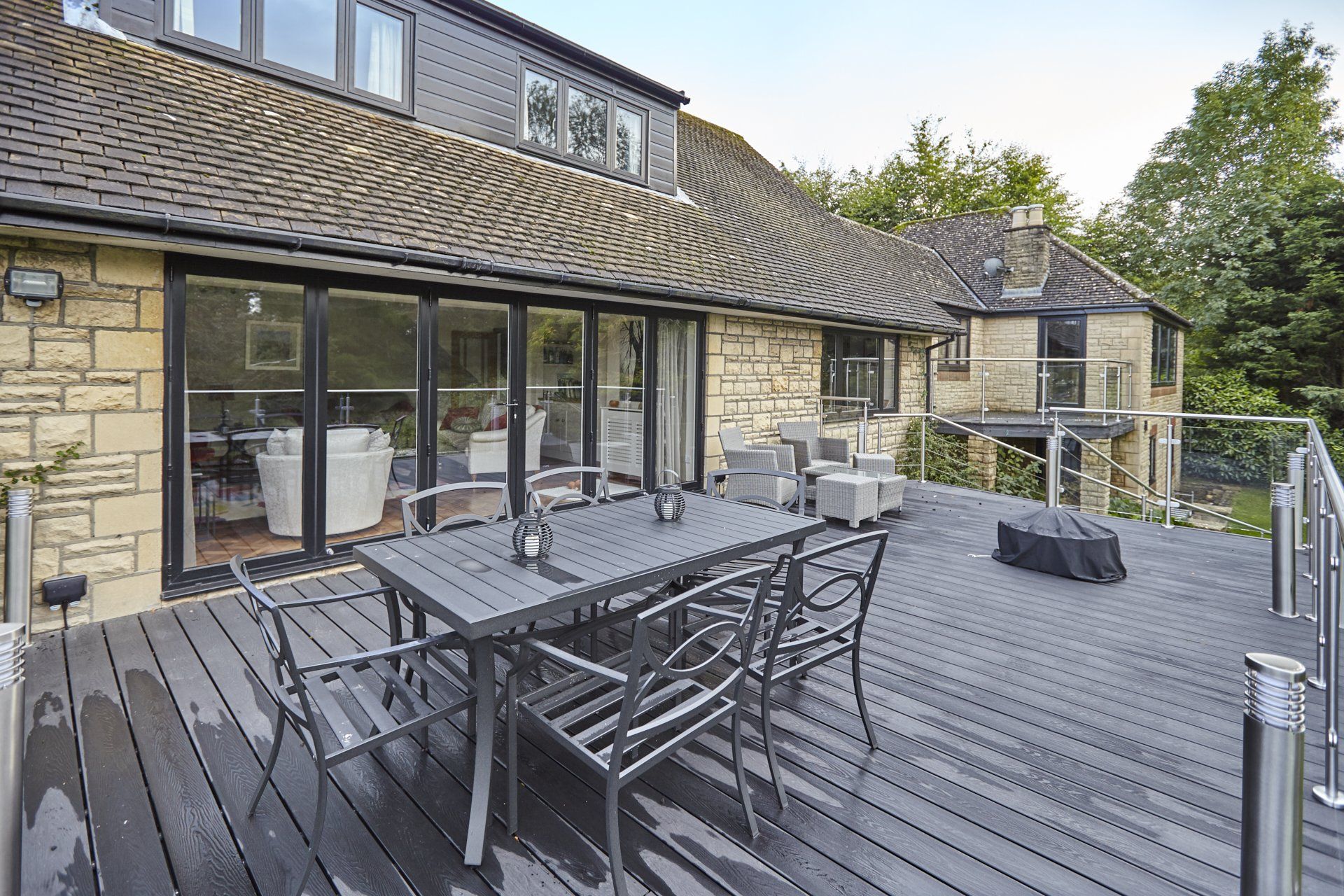 There is a large deck with a table and chairs on it.