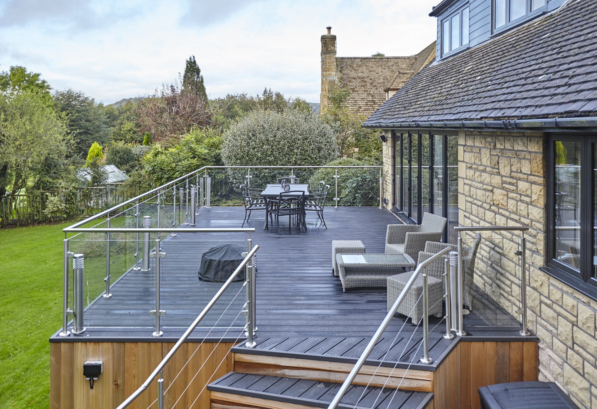 There is a large deck with a table and chairs on it.