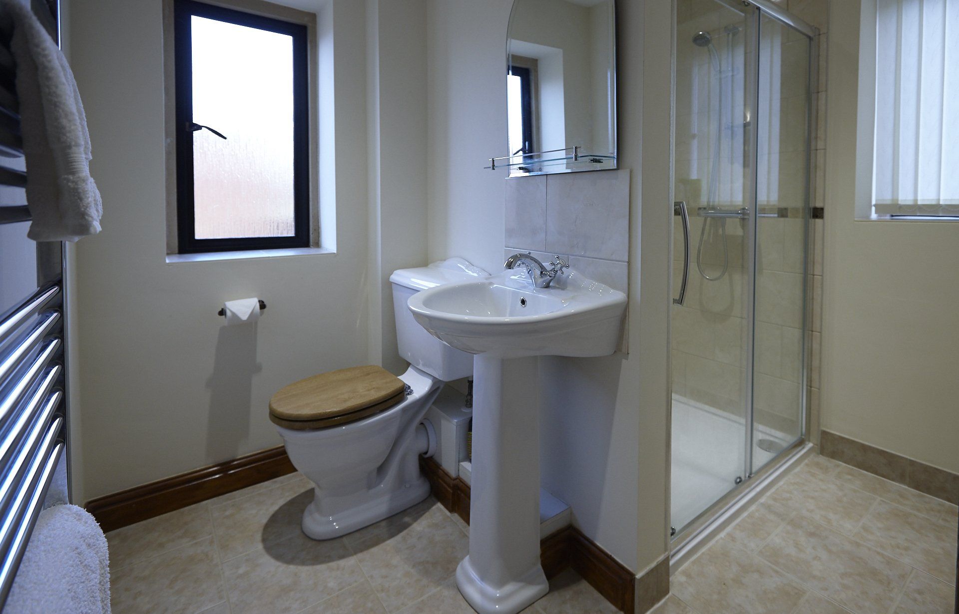 A bathroom with a toilet , sink , and shower.