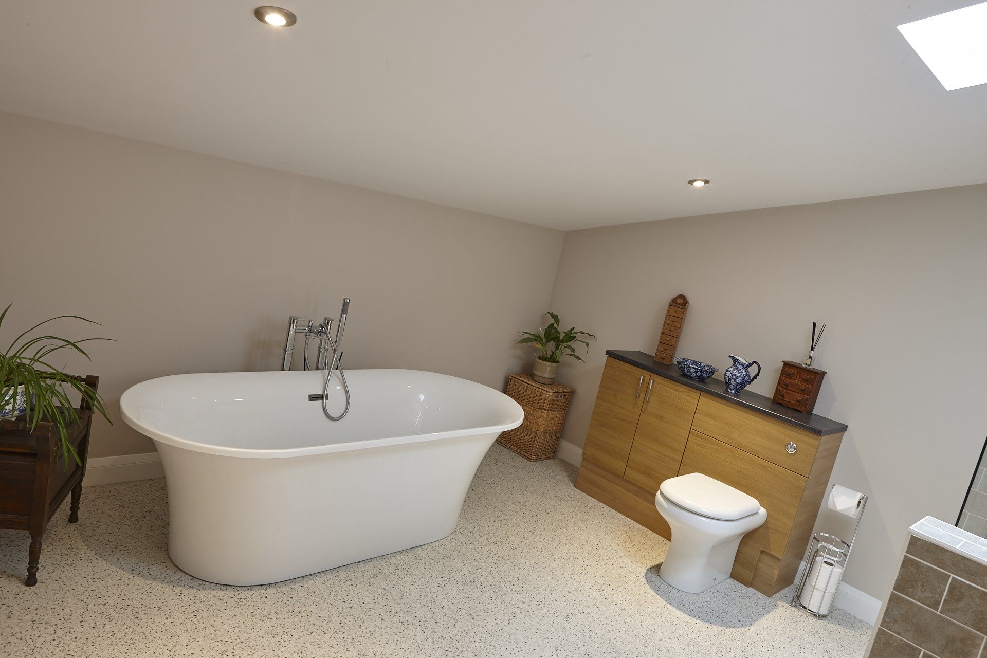 A bathroom with a bathtub , toilet , and dresser.