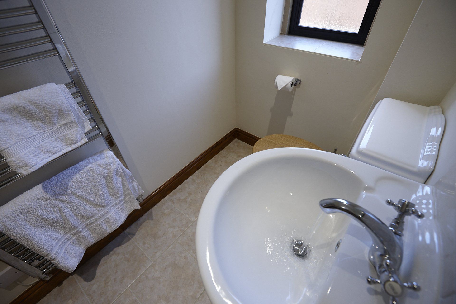 A bathroom with a sink , toilet , and towel rack.